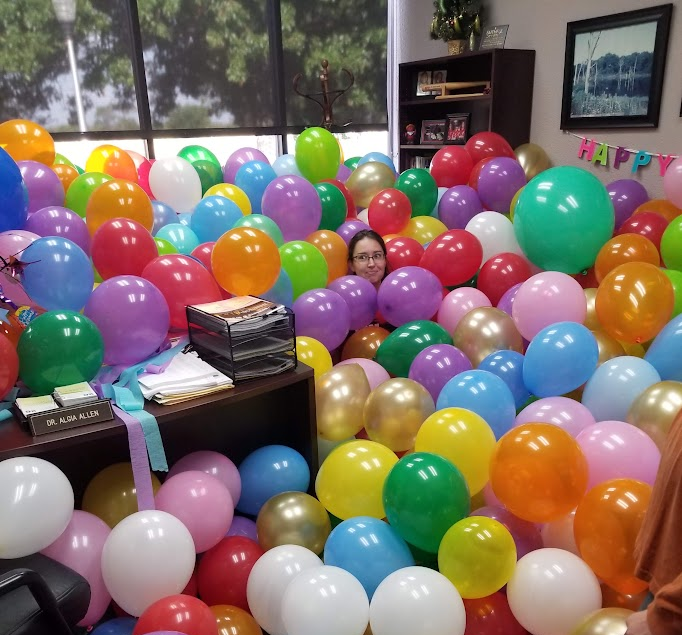 Lauren Befeld posing in balloons at TVCC Terrell event. 
