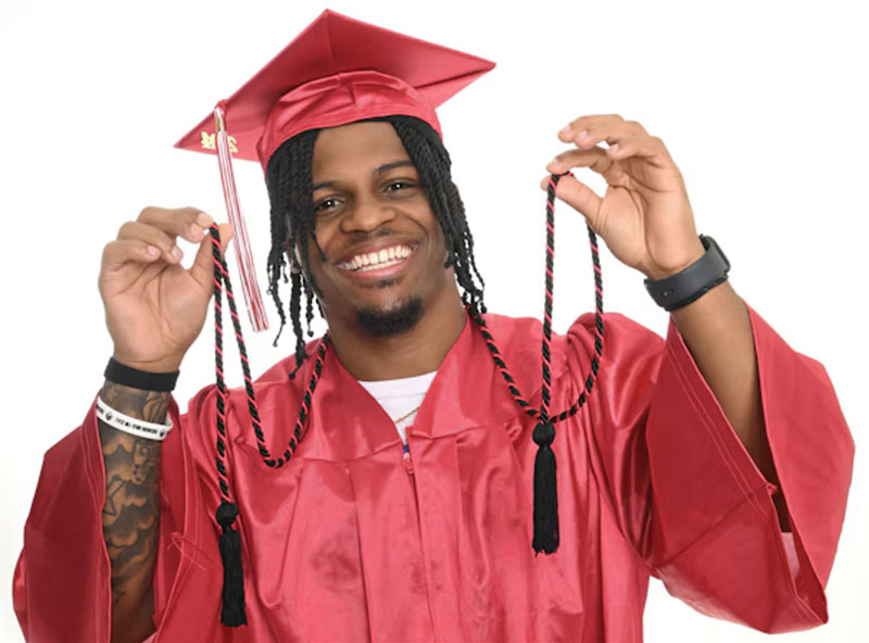 trinity valley community college graduate holding up the philanthropy cord